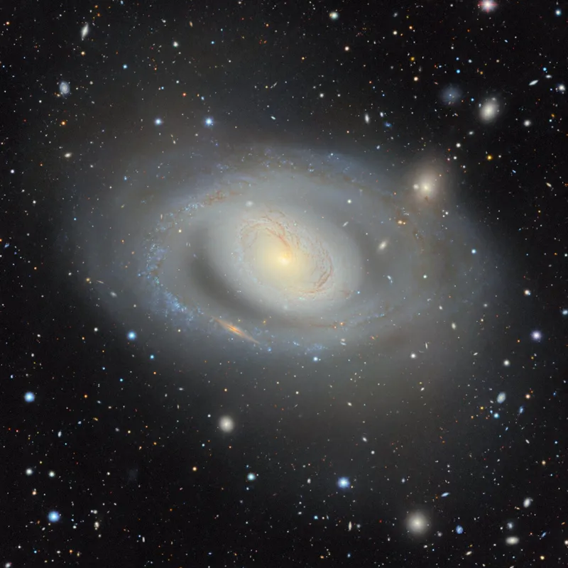 A deep-sky optical photo showing spiral galaxy Messier 96 and surrounding cosmic structures captured by the Dark Energy Camera as part of the DESI Legacy Imaging Surveys 2D universe map.