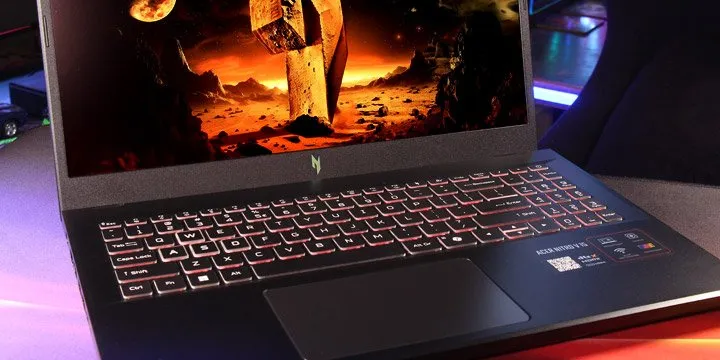 Ігровий ноутбук Acer Nitro V 15 із червоною підсвіткою клавіатури та динамічною сценою з відеоігри на великому дисплеї.