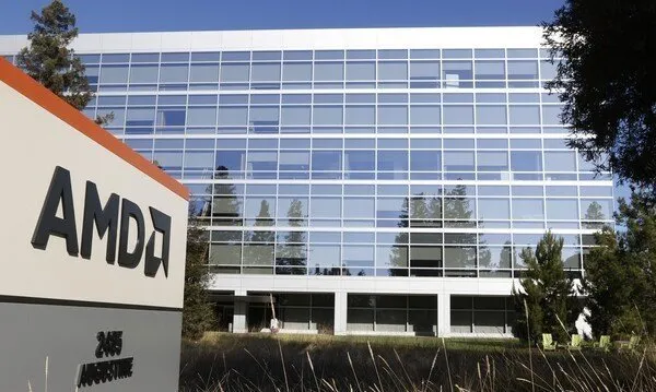 Сучасна корпоративна будівля AMD з великим скляним фасадом на тлі зелених дерев та приміщень.