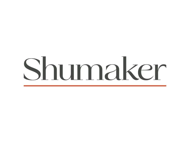 На чистому білому фоні велике слово Shumaker виконане чорним шрифтом із тонкою червоною горизонтальною лінією підкреслення.