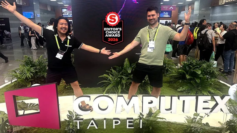 Двоє чоловіків святкують успіх на виставці Computex Taipei біля брендованої сцени з логотипом "Editor's Choice Award 2026".