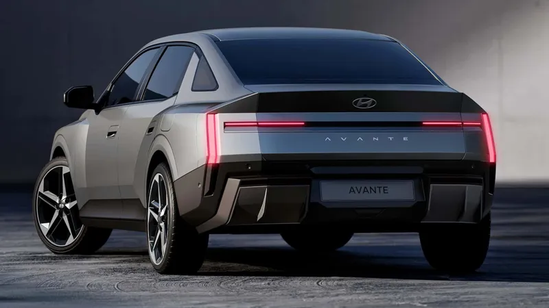 Сріблястий седан Hyundai Avante з яскравими задніми ліхтарями на фоні темного індустріального приміщення.