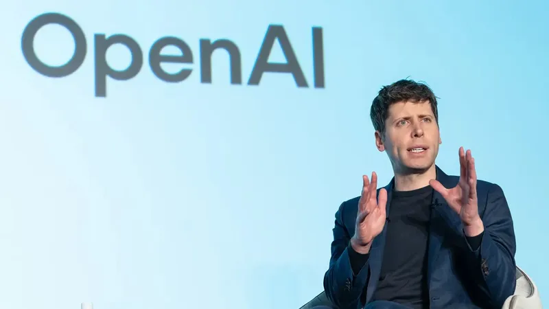 Сем Альтман виступає на сцені з жестами рук перед великим логотипом OpenAI на світло-блакичному фоні.