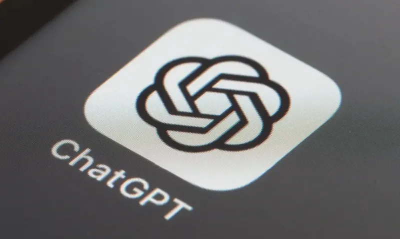 Макро-знімок іконки застосунку ChatGPT зі стилізованим вузловим логотипом, розташованої на екрані пристрою з темним фоном.