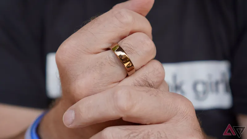 The sleek titanium Oura Ring 5 sitting on a charging dock next to a smartphone displaying health metrics.