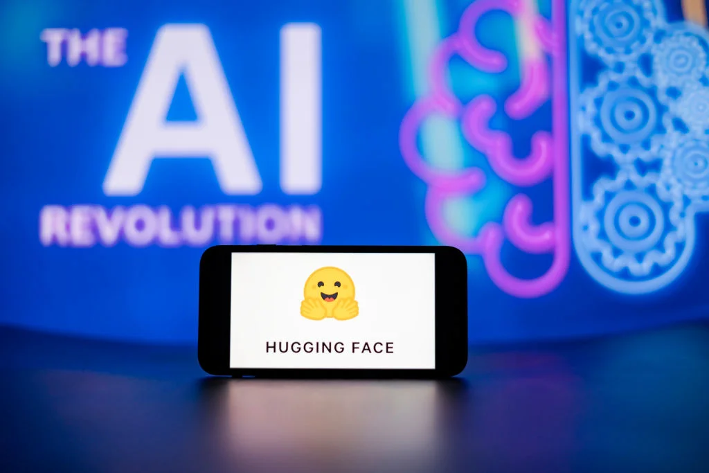 Логотип платформи Hugging Face на екрані смартфона на тлі символів штучного інтелекту