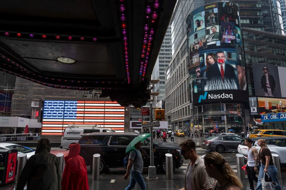 People walk past the Nasdaq MarketSite building in New York City.