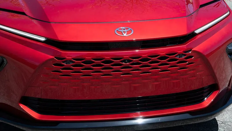 Стильний червоний фасад Toyota Crown Signia з характерною сітчастою решіткою та сучасним LED-освітленням.