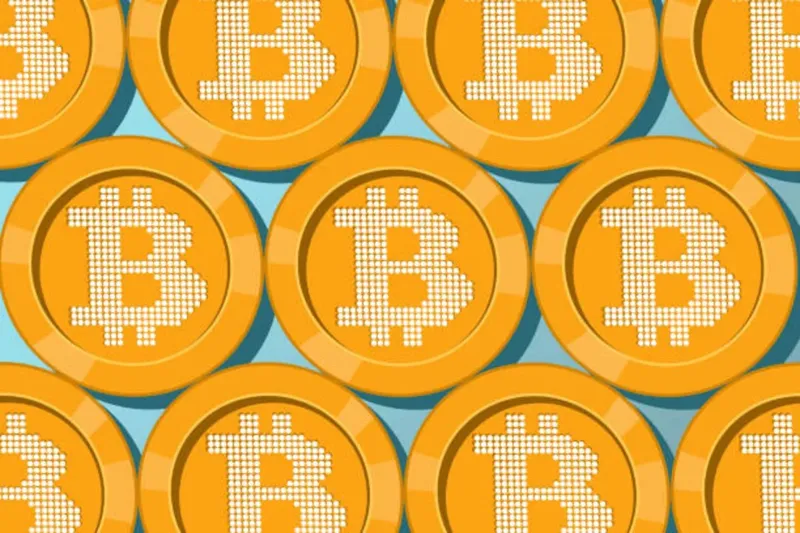 Кілька золотистих монет з логотипом Bitcoin на світло-блакитному фоні.