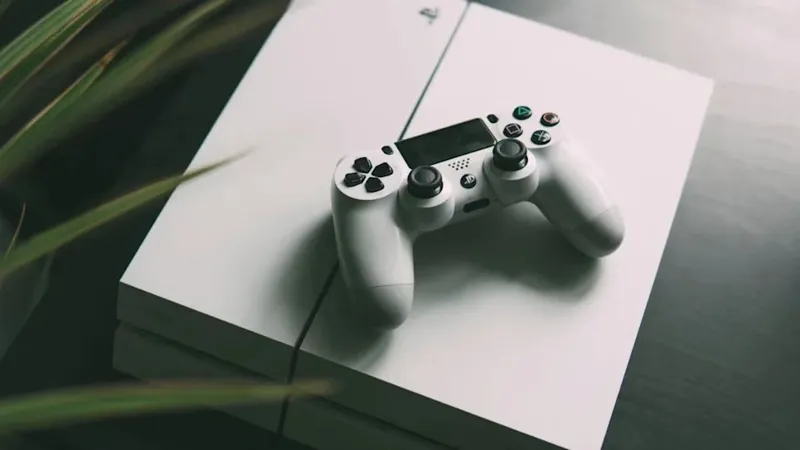 Геймер тримає геймпад консолі PlayStation на тлі ігрового дисплея
