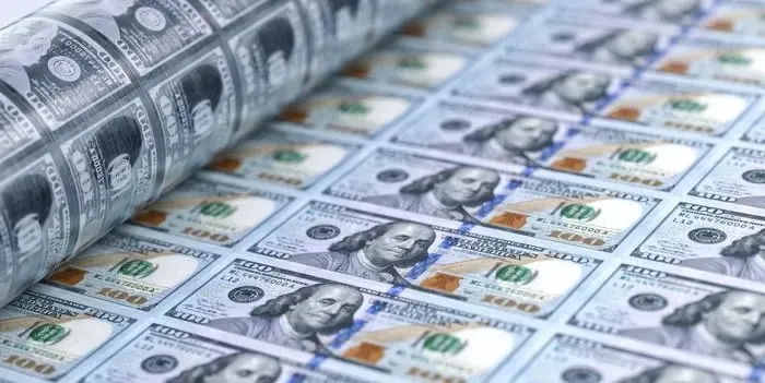 Близький план стосів американських доларів та розкиданих купюр на поверхні, що символізує фінансовий успіх і пасивний дохід.