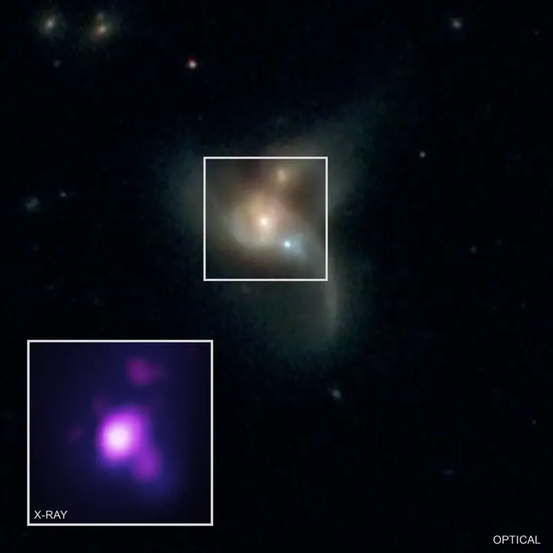 Artist rendering of three supermassive black holes consuming gas inside a distant early universe galaxy.
